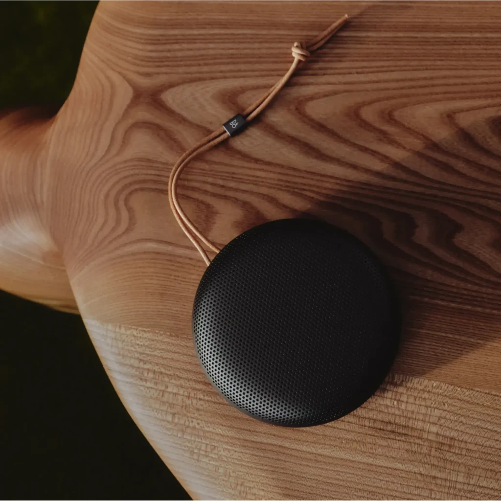 Bang & Olufsen Beosound A1 3rd Gen Warm Granite, vista lateral: rejilla perforada, botones de control y cordón de cuero con - Ítem4