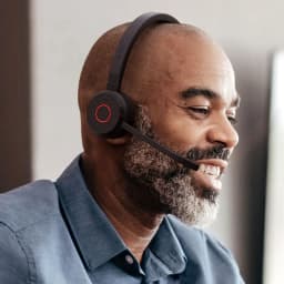 Jabra Evolve 65 TE Mono Negro, uso: hombre de perfil con auricular puesto, micrófono boom y botón rojo visible