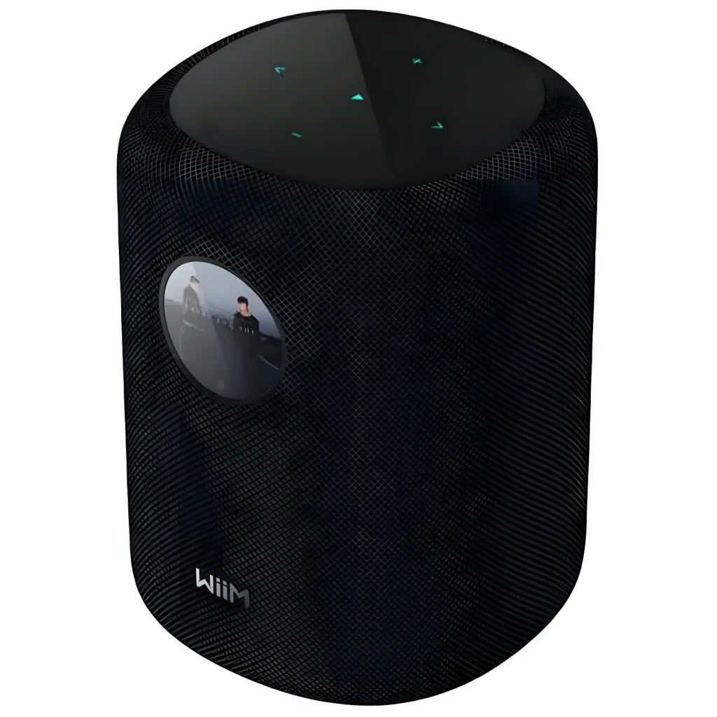 Wiim Sound noir, vue de face: enceinte cylindrique avec affichage horloge analogique et télécommande blanche incluse - Ítem1