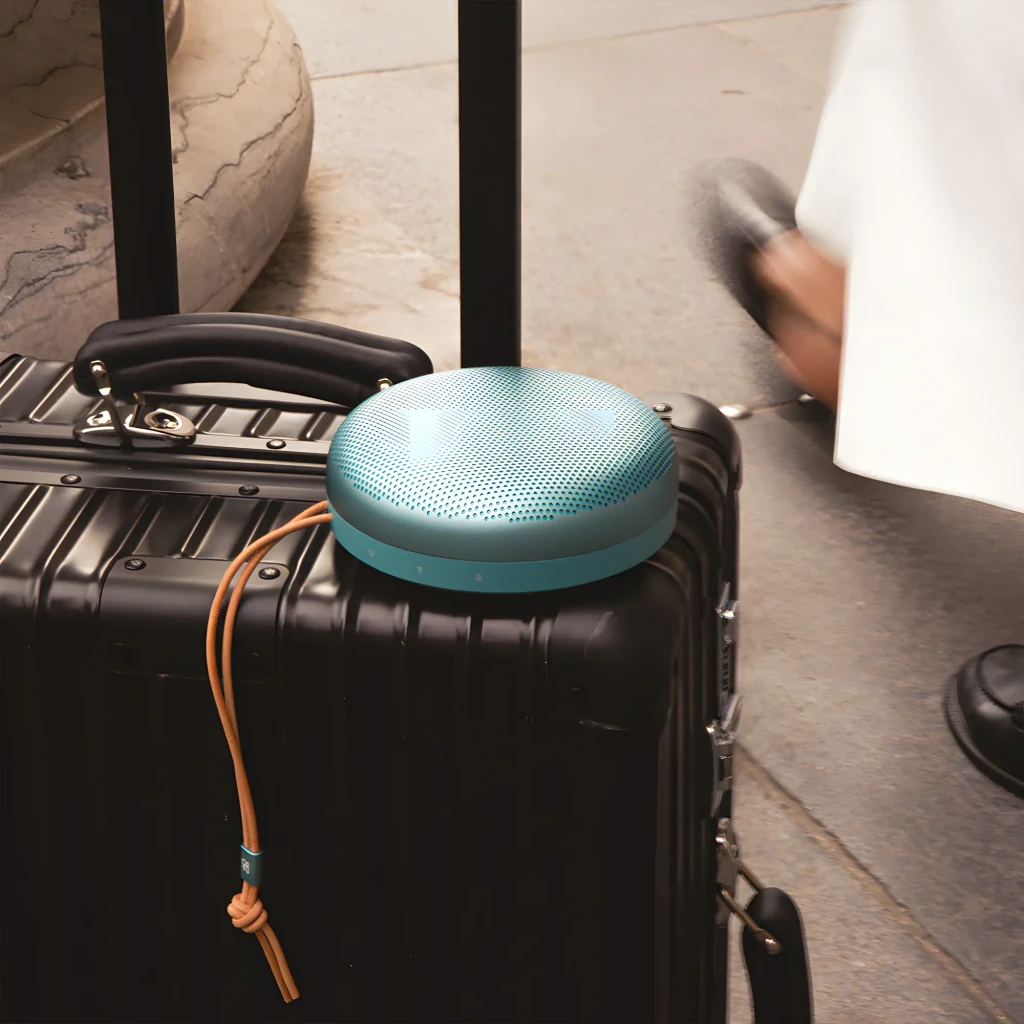 Bang & Olufsen Beosound A1 3ª Gen verde eucalipto, vista en ángulo: rejilla perforada superior, botones laterales y cordón - Ítem5