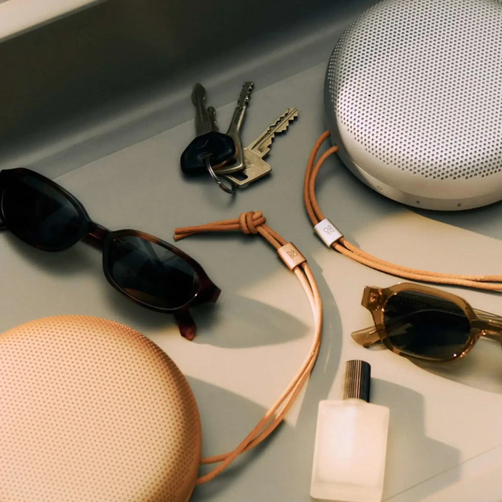 Bang & Olufsen BeoSound A1 3rd Gen Rouge Rustique, vue latérale: grille supérieure, boutons frontaux et cordon cuir beige - Ítem4
