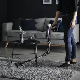 Rowenta X-Force Flex 9.60 Allergy RH2037WO Preto Roxo, uso: pessoa aspirando tapete em sala com tubo flexível dobrado