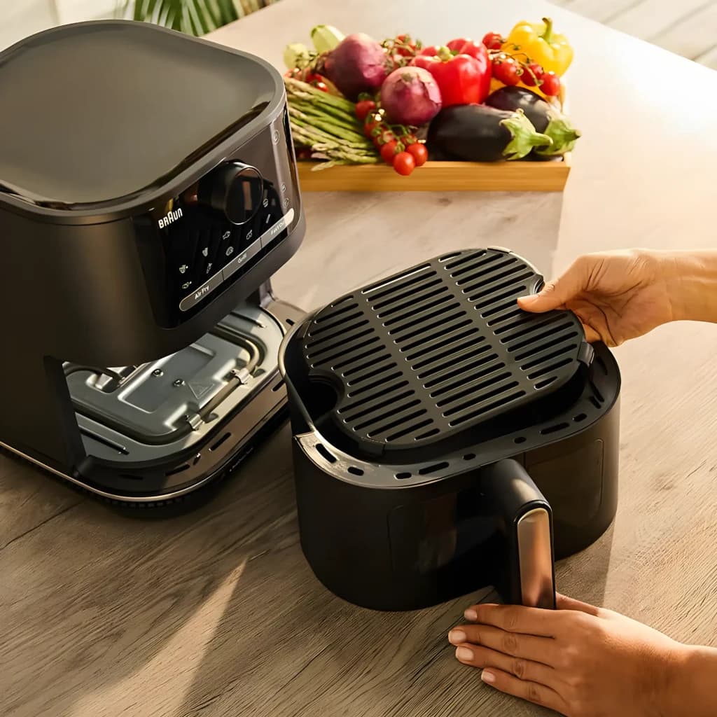 Braun Multifry 5 HF5075IBK Noir Gris, détail: mains retirant le panier avec grille, intérieur et panneau tactile visibles,
