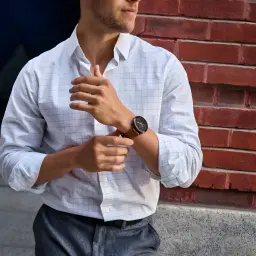 Montre Garmin Venu 4 45 mm gris ardoise au poignet, boîtier fin et écran circulaire, bracelet en cuir marron élégant, style urbain sophistiqué
