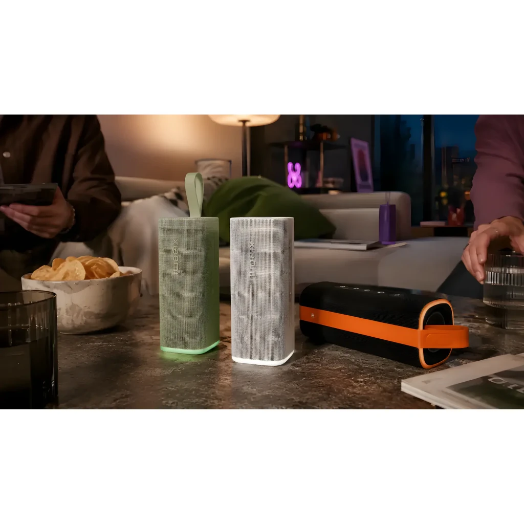 Caixa de som portátil verde com tecido texturizado, alça superior, botões laterais discretos e base iluminada em verde; formato retangular vertical elegante - Item4