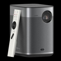 Proyector XGIMI Halo+ GTV gris con lente frontal, chasis metálico perforado, altavoces Harman Kardon integrados y control remoto blanco con rueda circular