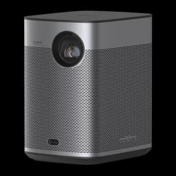 Proyector XGIMI Halo+ GTV 1080p, 700 lúmenes ISO, diseño compacto gris, lente frontal grande, rejilla metálica perforada y altavoces Harman Kardon integrados