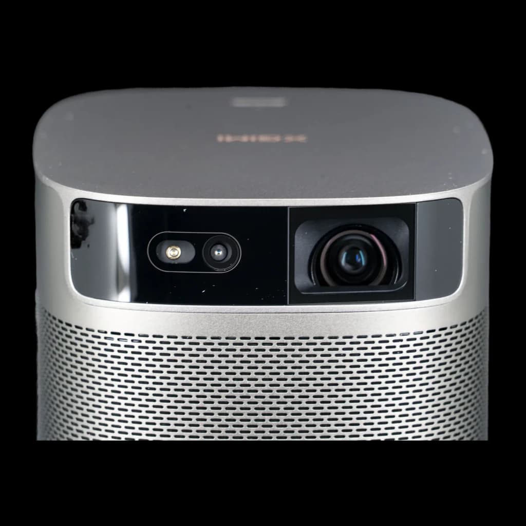 Frontal del Proyector XGIMI MoGo 2 Pro Gen 2 con lente grande y sensor, acabado gris metalizado y rejilla perforada que cubre el altavoz frontal