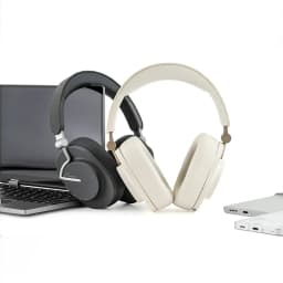 Casque Moondrop Edge Grey ANC hybride, arceau rembourré, oreillettes circum-aurales, finitions gris et crème, posé près d’un ordinateur portable argenté