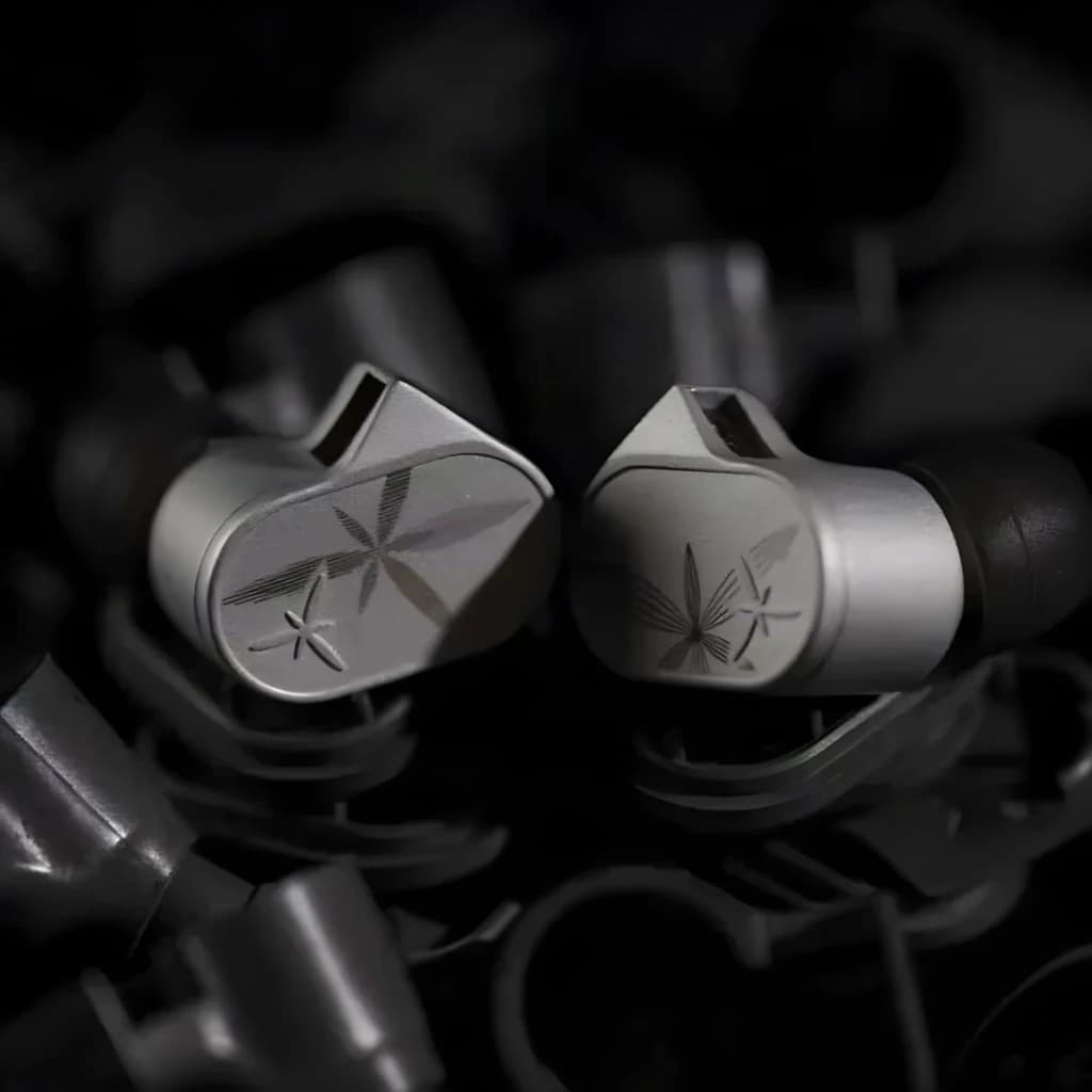 Écouteurs intra gris métallisé avec embouts noirs, coques angulaires et motifs gravés en étoile, finition mate premium, connecteur jack 4,4 mm équilibré