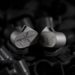 Écouteurs intra gris métallisé avec embouts noirs, coques angulaires et motifs gravés en étoile, finition mate premium, connecteur jack 4,4 mm équilibré