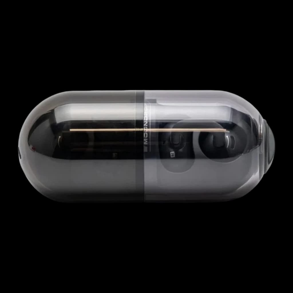 Boîtier ovale fumé et brillant abritant les écouteurs Moondrop Pill OWS Noir, coque translucide grise laissant voir les clips d’oreille compacts