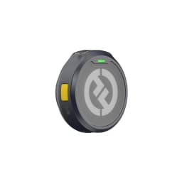 Microphone cravate sans fil compact noir, boîtier rond avec logo gris, bouton latéral jaune, témoin LED vert, clip discret pour vêtements