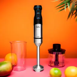 Jata Varinha Mágica JEBT1791 1500W Preto Aço inoxidável, vista frontal: varinha com copo e picador junto a frutas tropicais