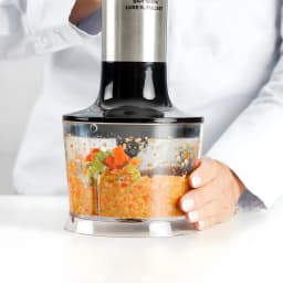 Taurus BAPI 1500 XL Luxe FullSet 1500W Inox Noir, utilisation: bol hachoir transparent mixant des légumes avec main tenant