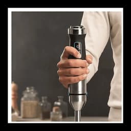 Cecotec Power TitanBlack 1500 XL preto, uso: mão segurando o cabo com botão azul e haste de aço inoxidável