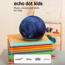 Amazon Echo Dot Kids 5e génération Dragon, enceinte sphérique bleue avec motif galaxie, anneau LED bleu, posée sur des cahiers colorés dans une chambre
