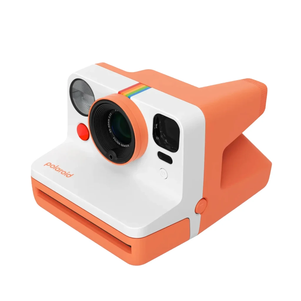 Polaroid Now Gen 3 Coral, vista frontal: objetivo autofocus, flash circular, botón disparador rojo y franja arcoíris - Ítem1