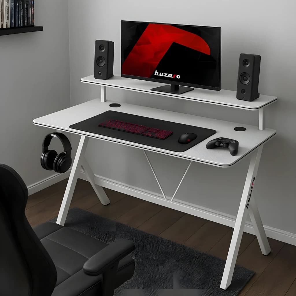 Huzaro Mesa Gaming Hero 1.9 Blanca, vista en escena: escritorio blanco con estante elevado, monitor, altavoces, auriculares