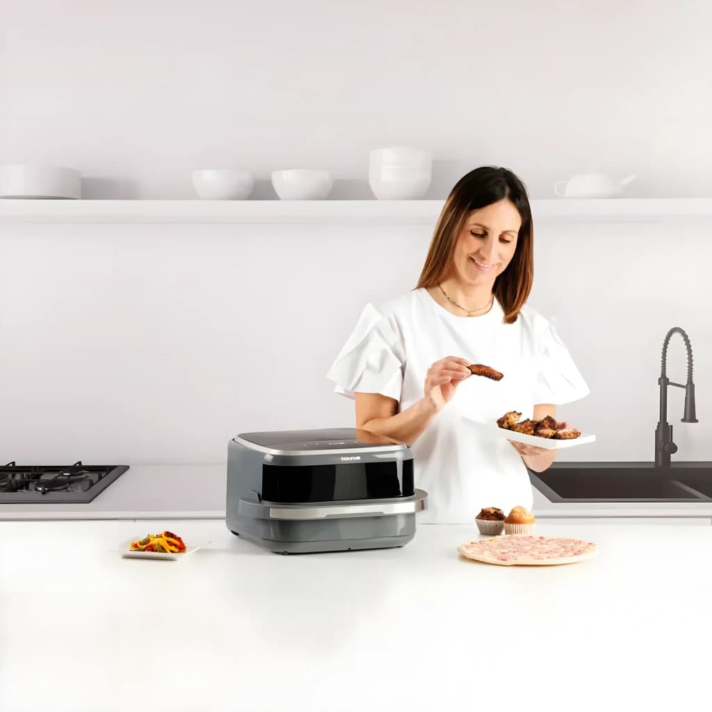 Taurus Air Fry PizzaGrill XL AF2200D Noir, utilisation cuisine: femme servant des aliments à côté de la friteuse avec pizza