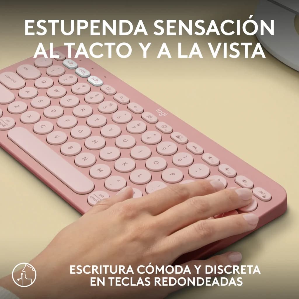 Logitech Teclado Pebble Keys 2 K380s Rosa, uso: mão digitando sobre teclas arredondadas em mesa bege