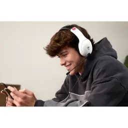 Turtle Beach Airlite Fit noir, lifestyle: jeune souriant portant le casque avec micro en jouant sur smartphone