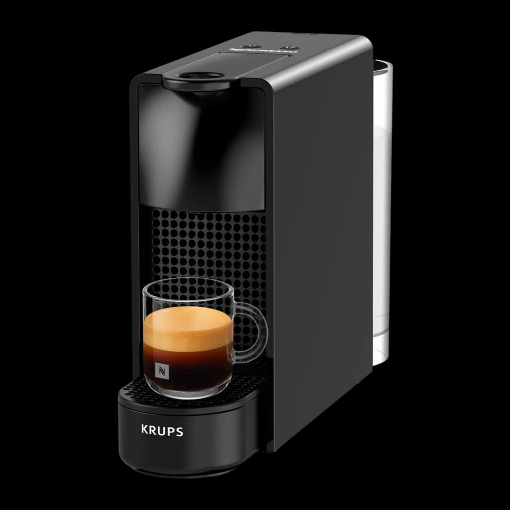 Krups Nespresso Essenza Mini noir, vue latérale: machine compacte avec tasse d'espresso sur la grille et façade perforée