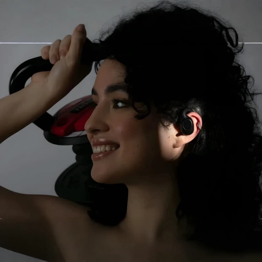 Nilox NXTWRUNBEATOR Bluetooth negro, uso deportivo: mujer con auricular en oreja sujetando kettlebell roja