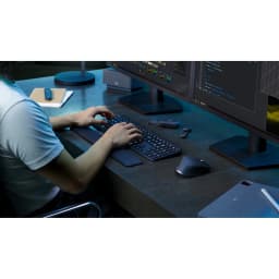 Logitech Teclado MX Keys S Inalámbrico Grafito, uso: persona escribiendo en escritorio con dos monitores y ratón MX en