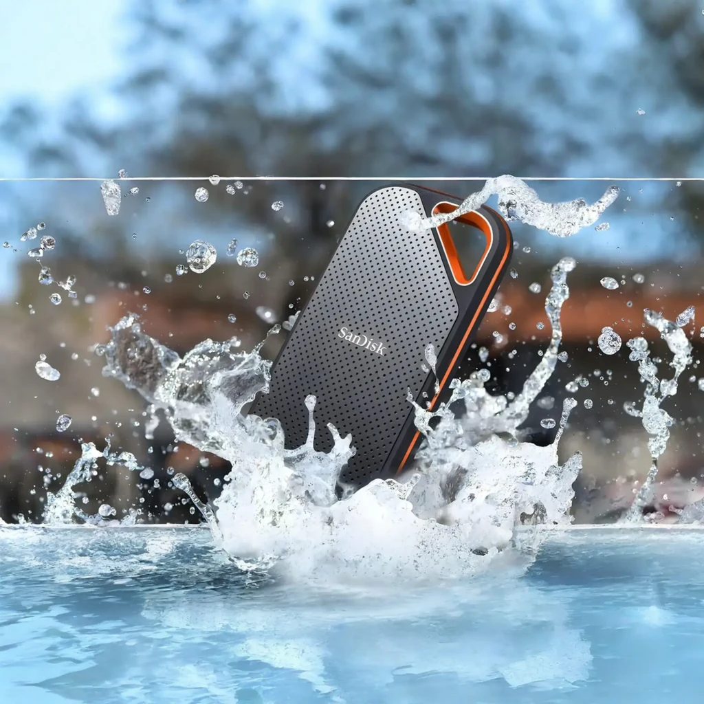 SanDisk Extreme Pro Portable SSD 2TB preto, vista frontal em ângulo: superfície perfurada, alça triangular laranja e logo - Item4