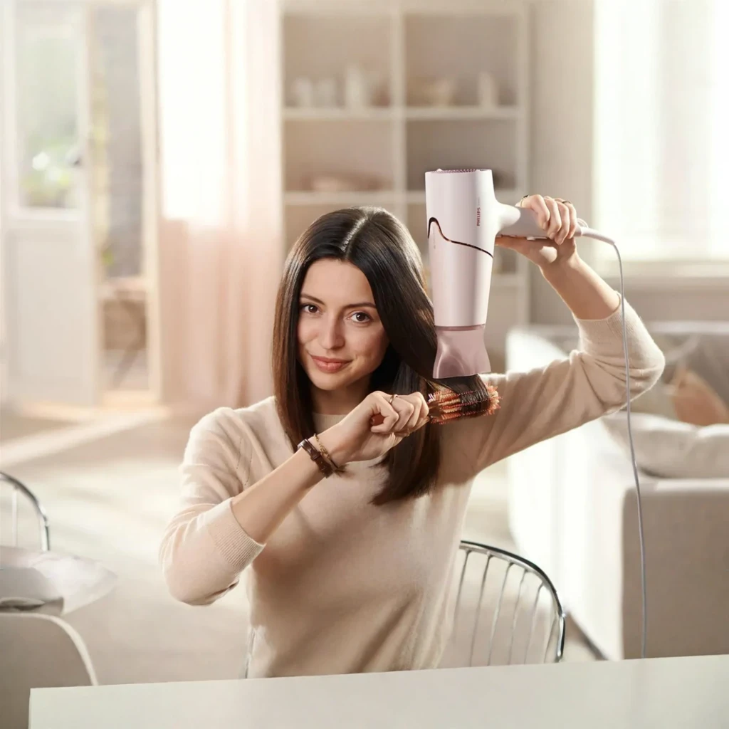 Philips Sèche-cheveux BHD530/00 Rose Blanc, vue latérale: sèche-cheveux avec buse concentrateur et diffuseur sur fond noir - Ítem3