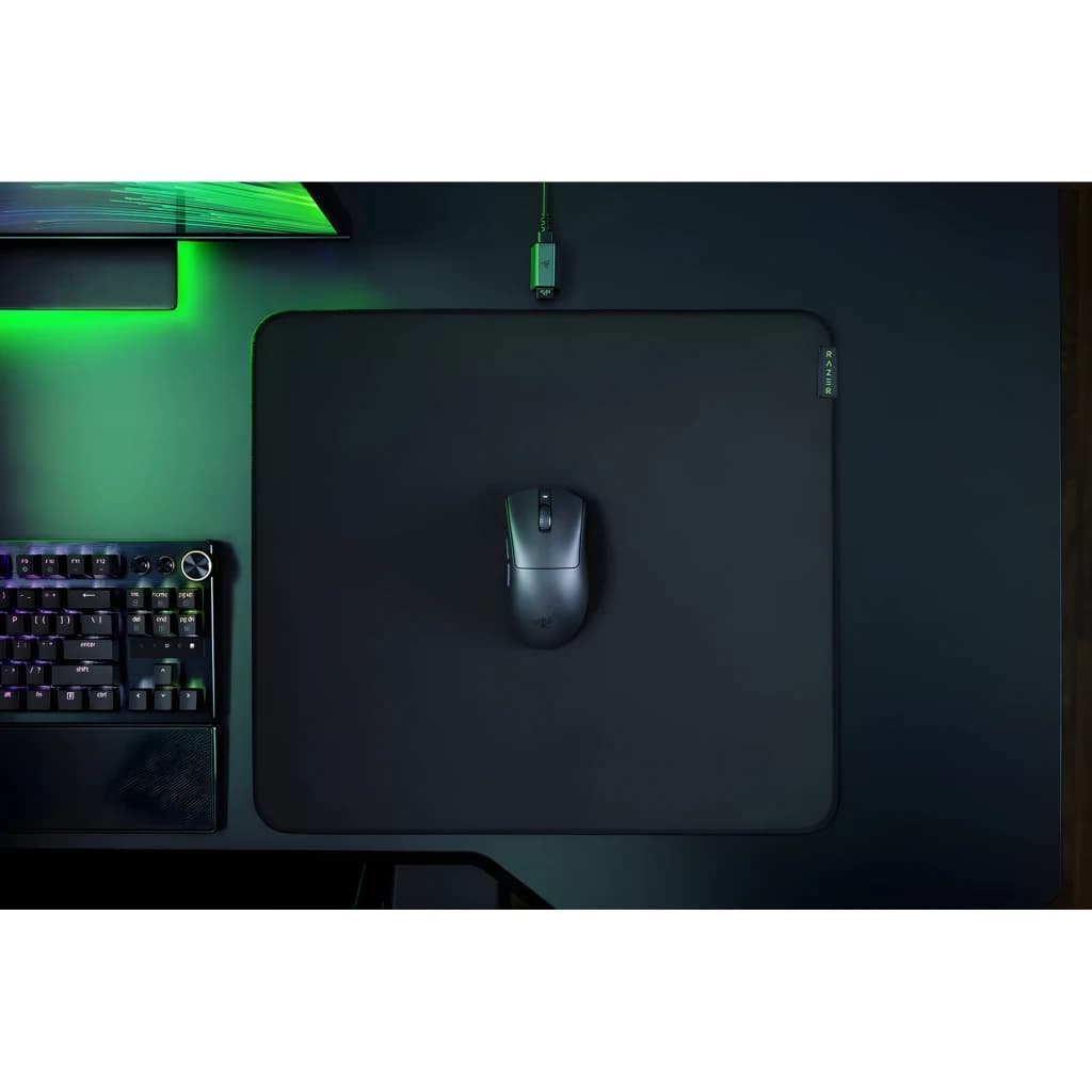 Razer DeathAdder V3 HyperSpeed noir, vue du dessus: souris sur tapis Razer sur bureau gaming avec clavier et éclairage vert