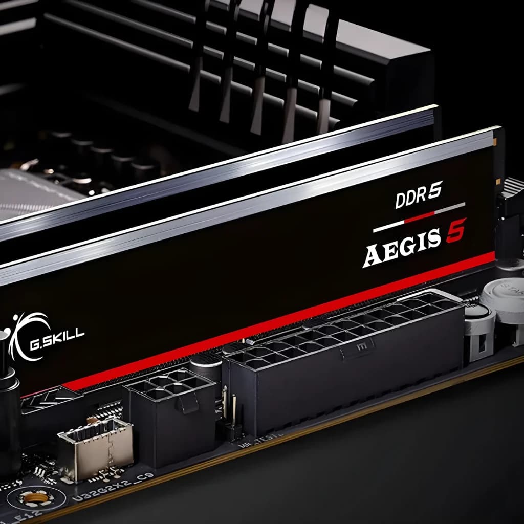 G.Skill Aegis 5 DDR5 64GB preto, instalada em placa-mãe: dissipador preto com faixa vermelha e logo DDR5 Aegis 5