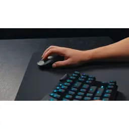 Logitech Rato G PRO X Superlight 2 Preto, uso: mão segurando o rato sobre mousepad ao lado de teclado gaming retroiluminado