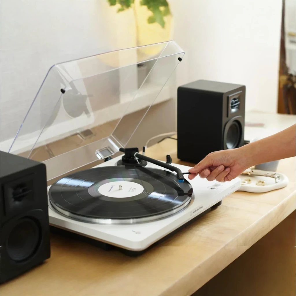 Audio-Technica AT-LP70XBTWS blanc, vue en perspective: couvercle acrylique ouvert, plateau noir avec logo, bras tonearm et - Ítem4