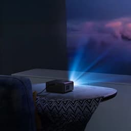 BlitzWolf Projector BW-V1 negro, vista en uso: proyecta haz de luz azul sobre pared en habitación oscura