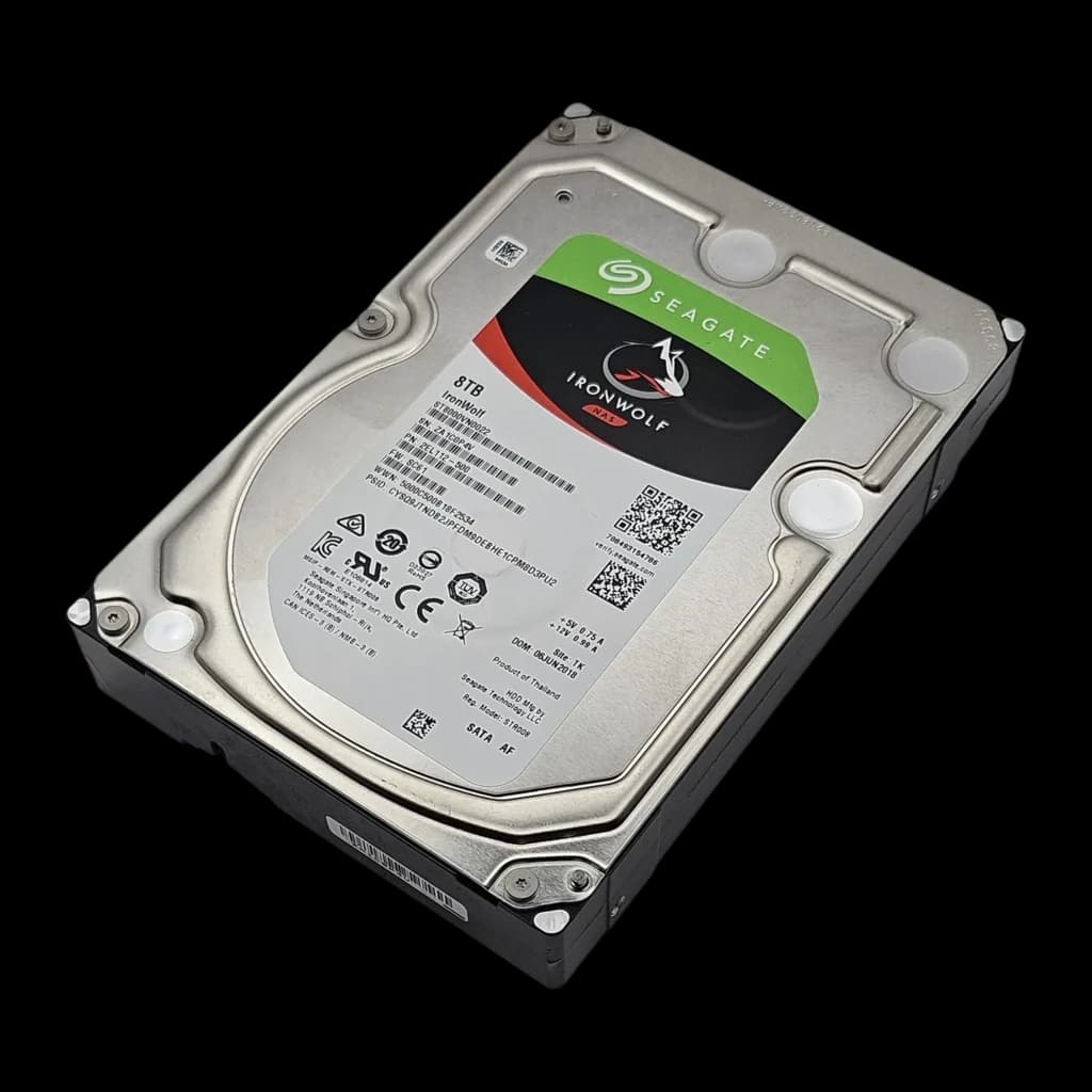 Seagate IronWolf ST8000VN0022 8TB, vista em perspectiva: carcaça metálica prateada, etiqueta e conector SATA visíveis