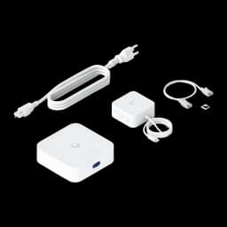 Router Ubiquiti UniFi Express 7 UX7 blanco compacto con puerto frontal azul, incluye adaptador de corriente, cable Ethernet, cable USB‑C y clip de montaje