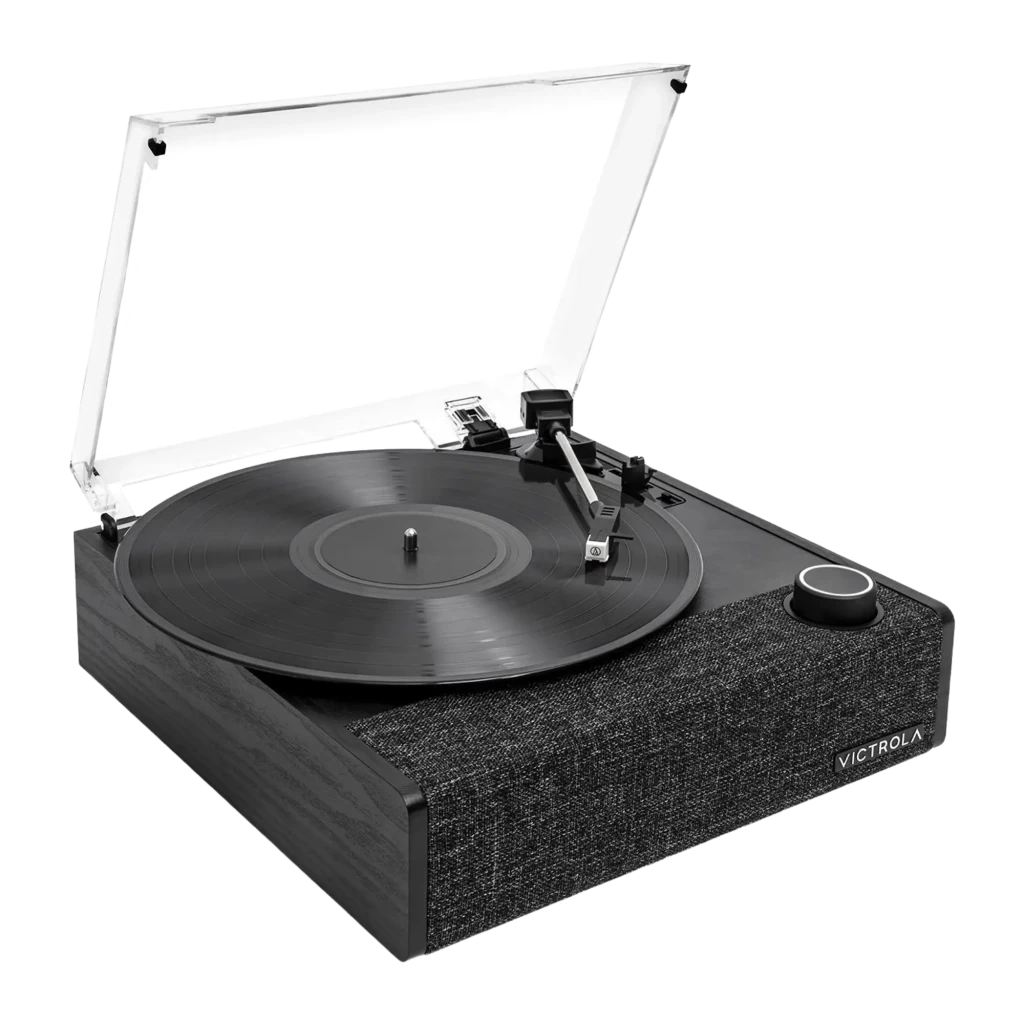 Tocadiscos Victrola Eastwood II VTA-74 con tapa transparente, plato negro, brazo recto y base textil gris; perilla frontal y logotipo Victrola visibles - Ítem1