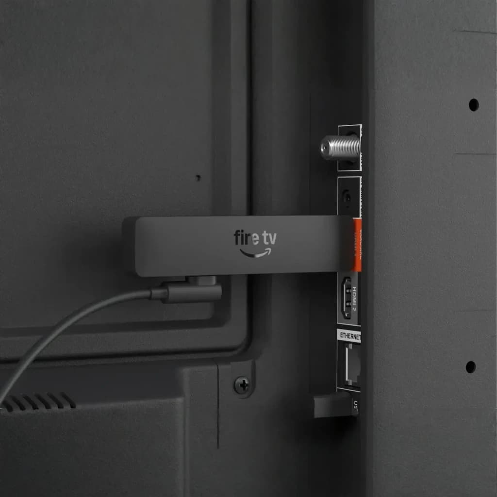 Leitor Multimédia Amazon Fire TV Stick HD 2026 conectado à porta HDMI da TV, dongle compacto com WiFi 6 e cabo USB, design preto com logotipo fire tv