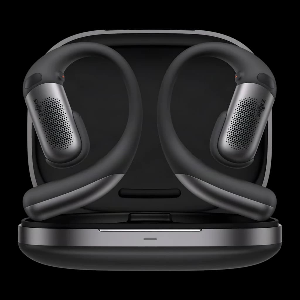 Estuche negro con dos auriculares open-ear Shokz OpenFit Pro; ganchos ergonómicos, rejillas metálicas de micrófono, acabado mate y base magnética de carga