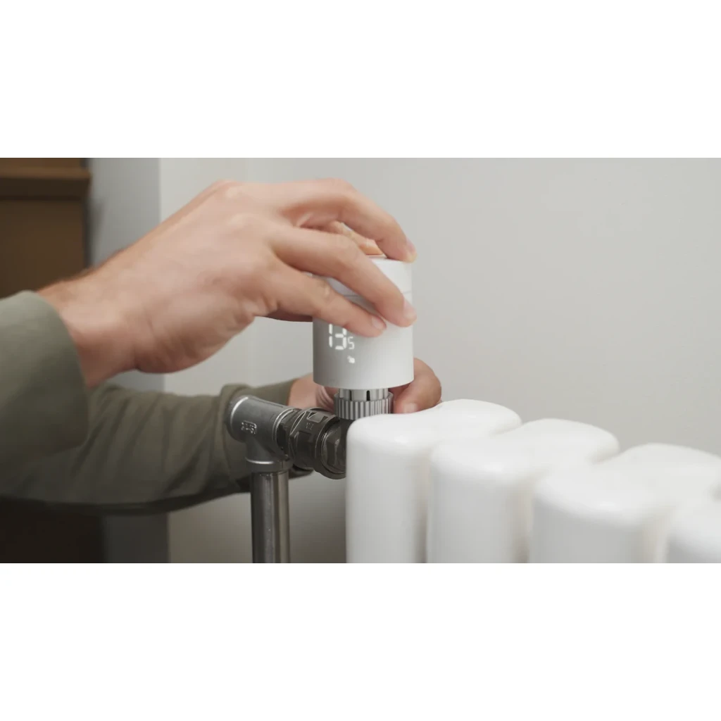 Thermostat pour radiateur Aqara Radiator Thermostat W600 Blanc Thread, Zigbee 3.0, pose: main fixant l'appareil sur valve