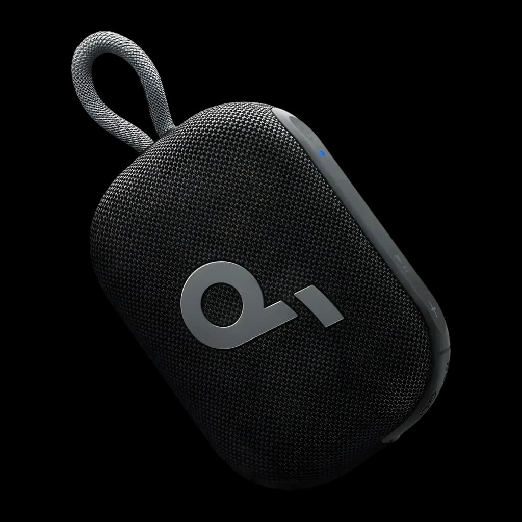 Enceinte compacte noire avec tissu maillé, logo Q argenté, sangle tressée, voyant LED bleu et grille arrondie; design robuste et portable IP67