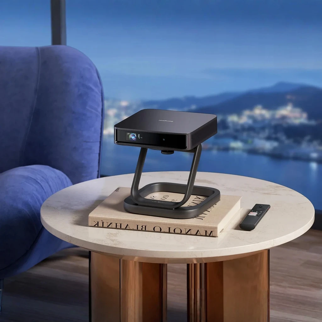 Dangbei Atom Smart 32GB Noir, vue de face en angle: projecteur sur support en Z avec objectif et grille du haut-parleur - Ítem5