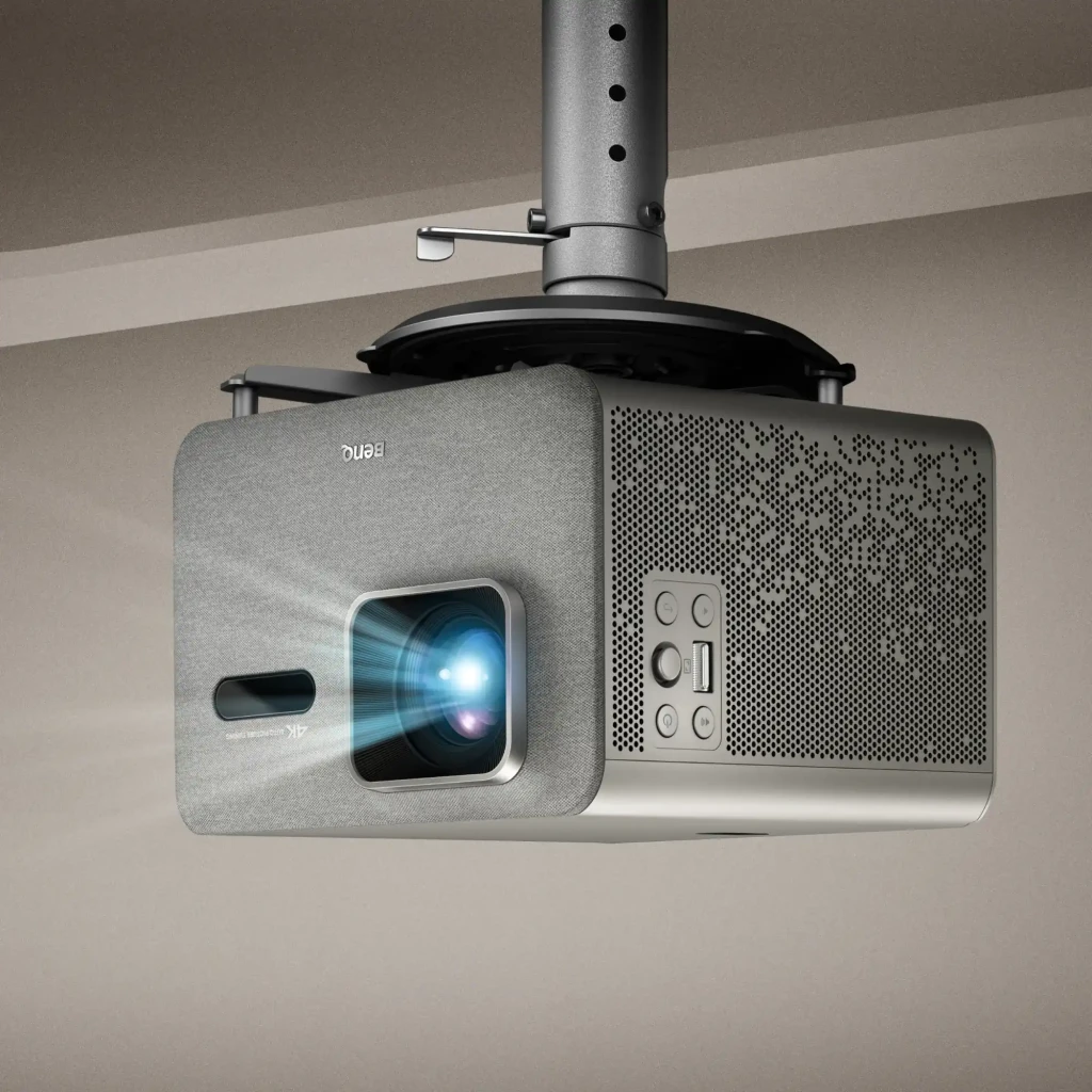 BenQ Proyector TK705i 4K UHD 3000lm Gris, vista frontal-lateral: objetivo, rejilla tela y logo BenQ visibles - Ítem6