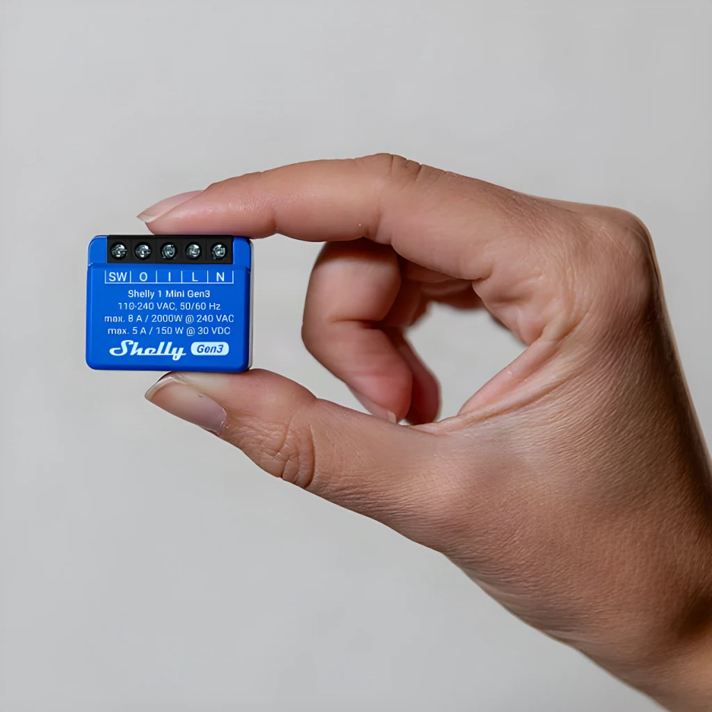 Relais intelligent Shelly 1 Mini Gen3 Bleu WiFi 2,4 GHz + Bluetooth 8A, en main: face bleue avec bornes SW O I L N