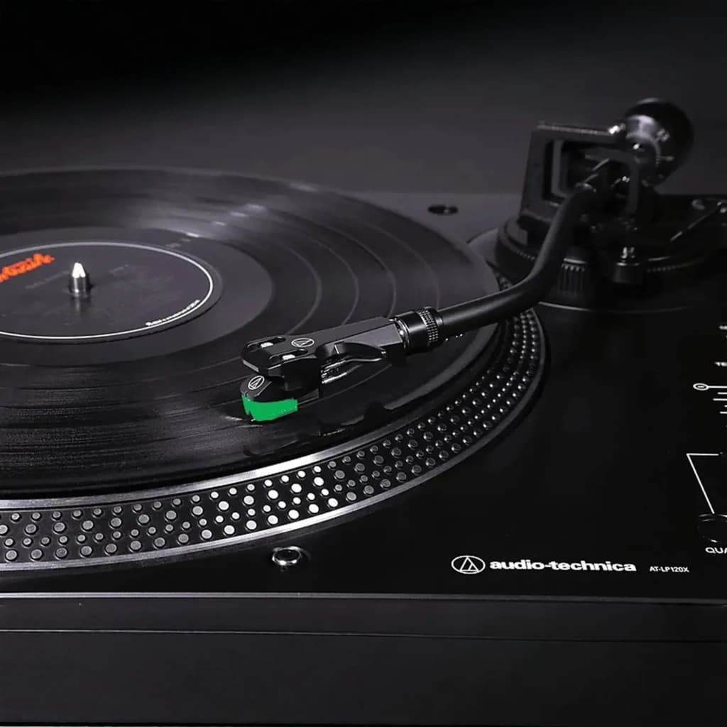 Audio-Technica AT-LP120X noir, détail: cellule avec diamant vert posé sur disque vinyle en rotation