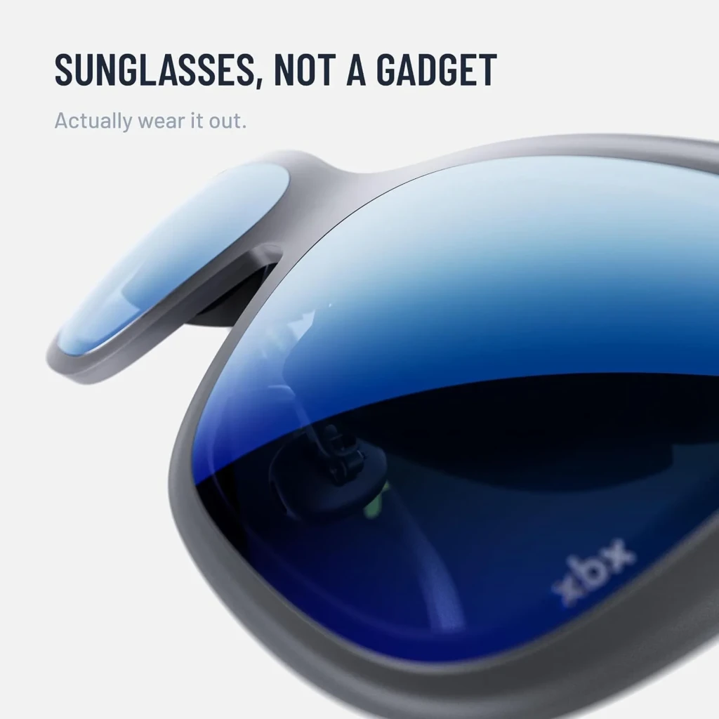 XREAL XBX A01+ Lunettes AR Gris, vue diagonale: verres bleus miroir et branche avec logo XBX jaune fluorescent - Ítem4