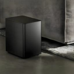 Ultimea Poseidon D80 BOOM Soundbar Negro, subwoofer en salón: caja compacta negra mate sobre suelo junto a sofá