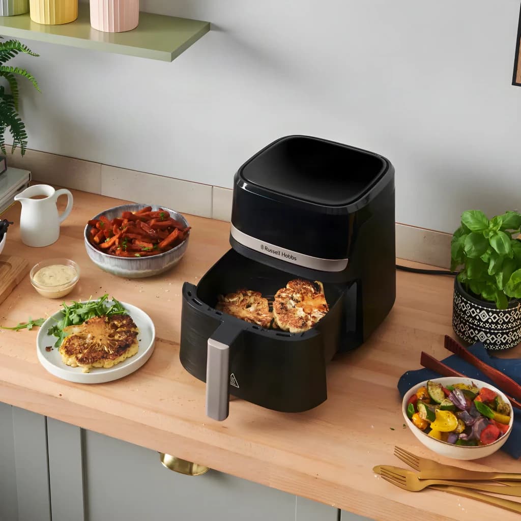 Russell Hobbs SatisFry 4.3L noir, vue lifestyle: tiroir ouvert avec aliments cuits sur plan de travail de cuisine